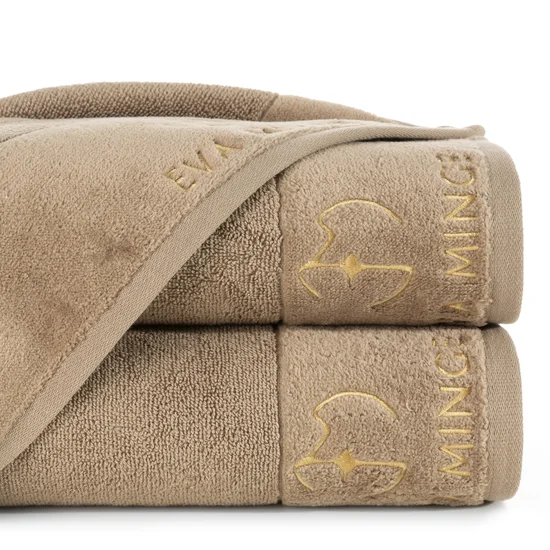 EVA MINGE Ręcznik GAJA z bawełny frotte z welwetową bordiurą i haftem z logo kolekcji - 70 x 140 cm - beżowy