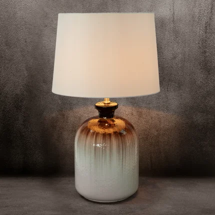 Lampa stołowa LIVIA na podstawie ze szkła z abażurem z matowej tkaniny Lampa stołowa LIVIA na podstawie ze szkła z abażurem z matowej tkaniny - 38 x 43 x 73 cm